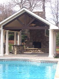 outdoor fireplace with stone bar and concrete paver patio