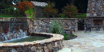 stone fireplace, patio and water feature