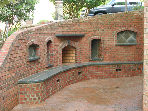fireplace built into existing brick retaining wall